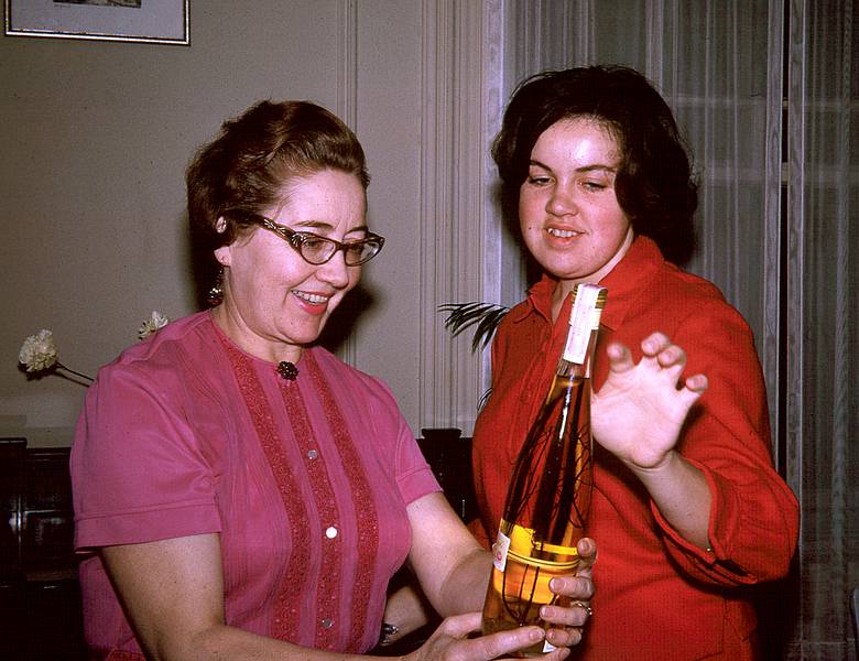 Feb 1964 - At Eriks' and Velta's in Jamaica Plain, Boston, MA.<br />Velta and Helga (Velta's sister Mirdza's daughter) admiring a liquor bottle.