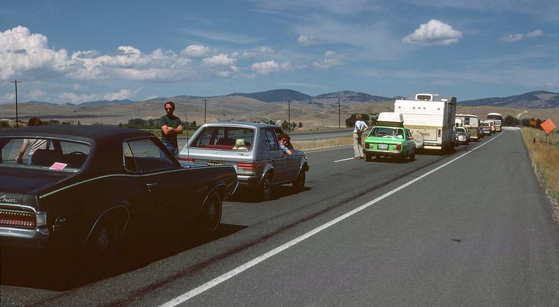August 16, 1979 - I-90, Montana.<br />Our two cars in a traffic jam on I-90 due to construction.<br />Ronnie is between the cars and Baiba is leaning out the window of the Dodge Omni. Julian is leaning out on the far side of the Cougar.
