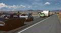 August 16, 1979 - I-90, Montana.<br />Our two cars in a traffic jam on I-90 due to construction.<br />Ronnie is between the cars and Baiba is leaning out the window of the Dodge Omni. Julian is leaning out on the far side of the Cougar.