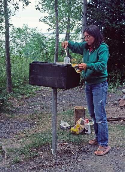 August 16-30, 1987 - Camping on Burton Island on Lake Champlain, Vermont.<br />Joyce cooking dinner and thinking: why do they have to put the grill so high.