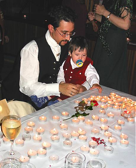 Aug 31, 2001 - Inga and Eric's wedding reception and Atli's 60th birthday celebration, Eskifjrur, Iceland.<br />Gujn, in Eric's lap, admiring all the lit candles in front of them.