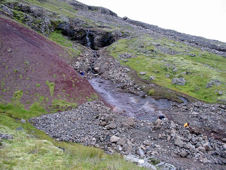 Sept 1, 2001 - Eskifjrur, Iceland.<br />Hillside with stream across valley from town where a mudslide uncovered some peculiarly round rocks.