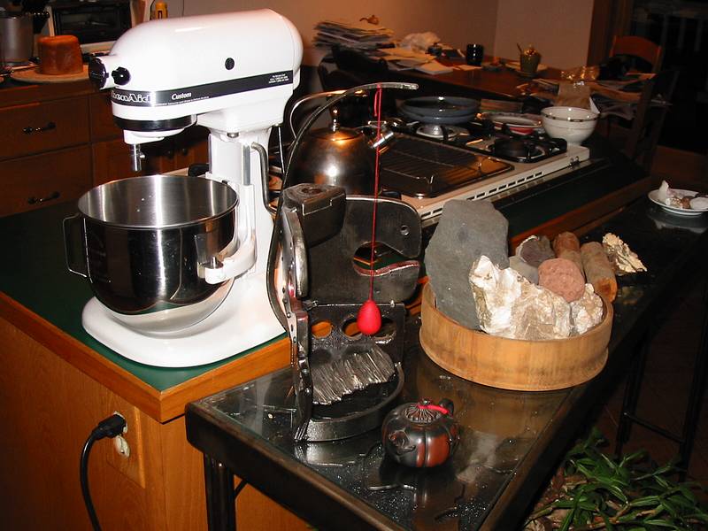 Dec 12, 2002 - Merrimac, Massachusetts.<br />Joyce's metal sculpture, a small teapot, rocks collected mainly in Iceland<br />all on Joyce's steel table (the Kitchen Aid mixer just happens to be there).