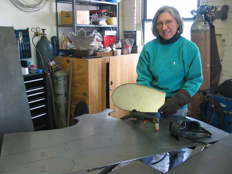 March 4, 2003 - Joyce's studio in Amesbury, Massachusetts.<br />Chicago's Navy Pier Project.<br />Joyce holding one of the 75 white pine cone scales.