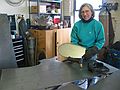 March 4, 2003 - Joyce's studio in Amesbury, Massachusetts.<br />Chicago's Navy Pier Project.<br />Joyce holding one of the 75 white pine cone scales.