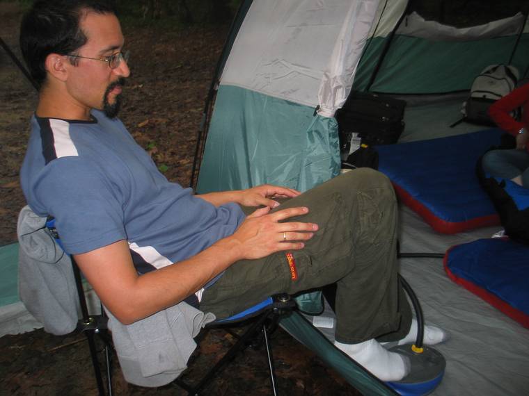 June 16, 2005 - White Lake State Park, Tamworth, New Hampshire.<br />Eric pumping up his air mattresses.<br />This photo was taken through the netting.