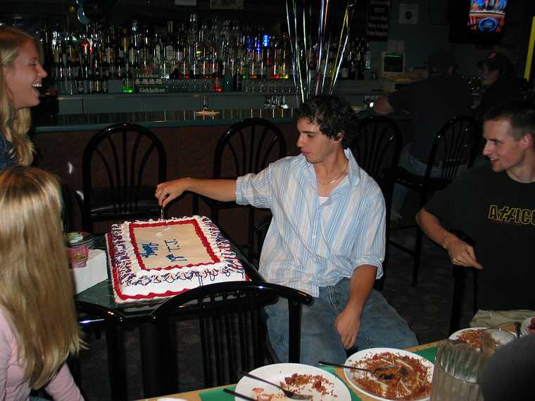 October 2, 2005 - Tiki Lau II Restaurant, Amesbury, Massachusetts.<br />T.J.'s 18th birthday celebration<br />T.J. casually cutting the birthday cake.