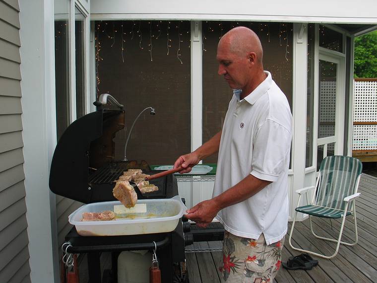 July 4, 2006 - At Uncle Tom's cabin, South Hampton, New Hampshire.<br />Tom grilling the meat.