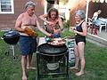 July 13, 2008 - Lawrence, Massachusetts.<br />The making of a Spanish paella (Time-Life: The Cooking of Spain and Portugal).<br />Paul and Joyce adding pepper and salt to the sofrito while Jim holds the hot pan.