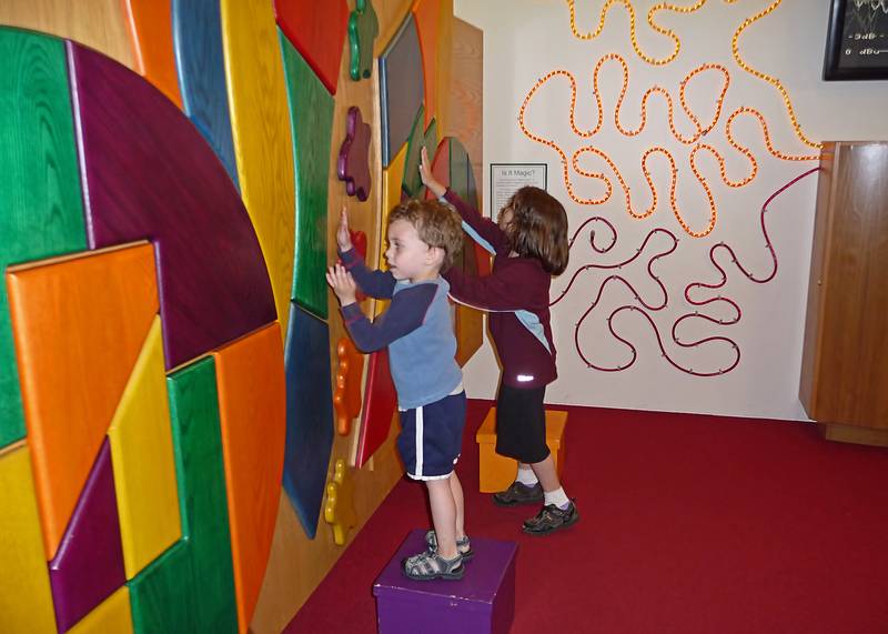 Matthew and Miranda making music by touching the wooden panels.<br />July 1, 2010 - Childrens' Museum in Dover, New Hamshire.