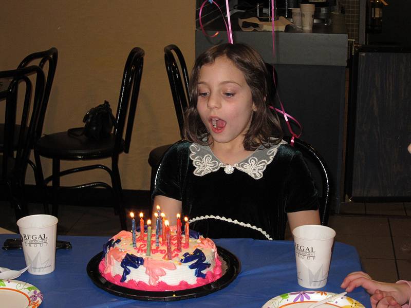 Miranda about to blow out the candles (and she did do a good job).<br />Miranda's 9th birthday celebration.<br />Jan. 2, 2011 - Regal Cinemas, Bellingham, Massachusetts.