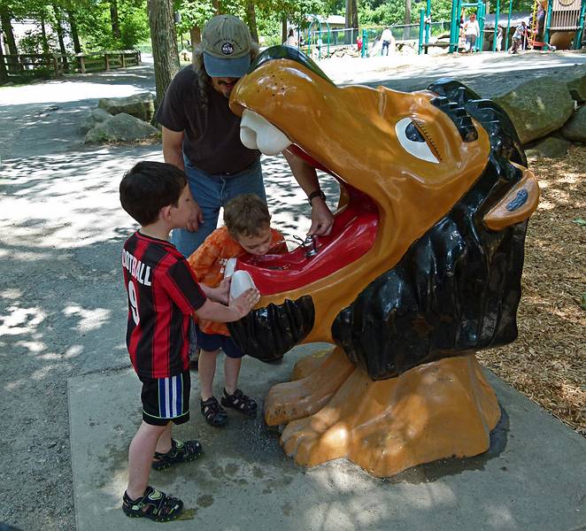 Marks and Matthew drinking from a lions mouth with the aid of Carl.<br />June 18, 2011 - Southwick Zoo, Mendon, Massachusetts.