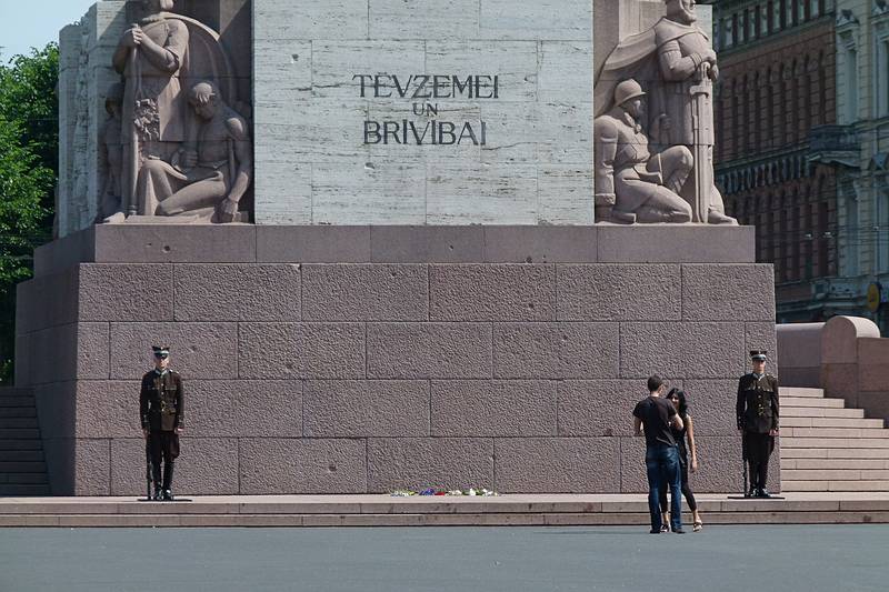 Guards (and a couple) at the base of the Freedom Monument.<br />Text reads: For Fatherland and for Freedom.<br />June 12, 2011 - Riga, Latvia.