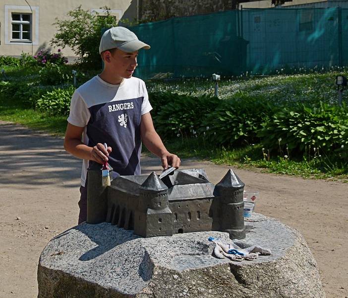Boy cleaning a model of the castle.<br />At the Cesis castle ruins.<br />June 10, 2011 - Cesis, Latvia.
