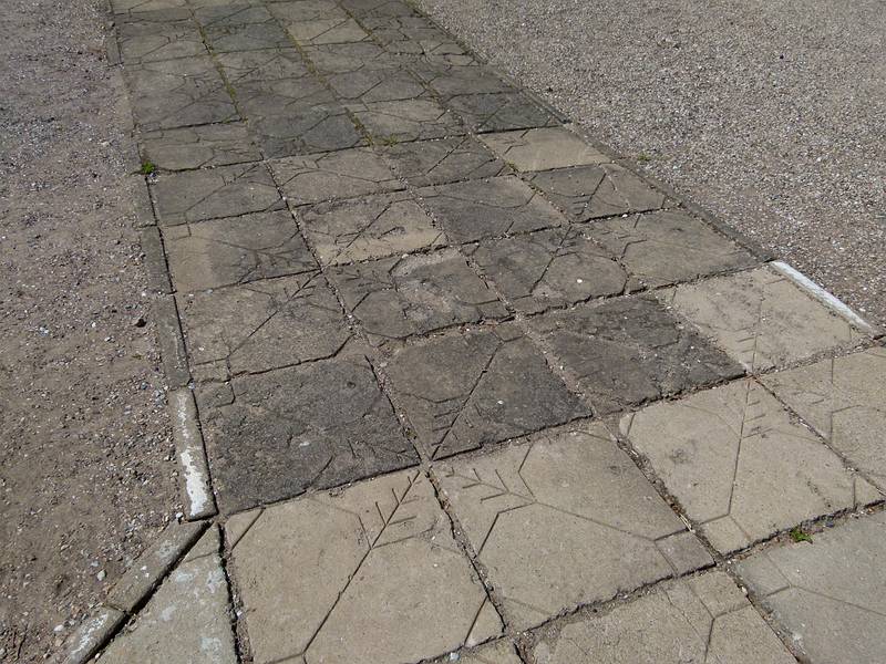 Latvian patterns in tiles in walkway to the garden door of the palace.<br />Birinu Palace grounds.<br />June 11, 2011 - Birini, Latvia.