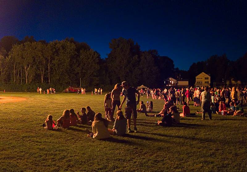 The crowd lit by the bonfire.<br />Old Home Days bonfire evening.<br />August 12, 2011 - Athletic field in front of the Donahue School, Merrimac, Massachusetts.