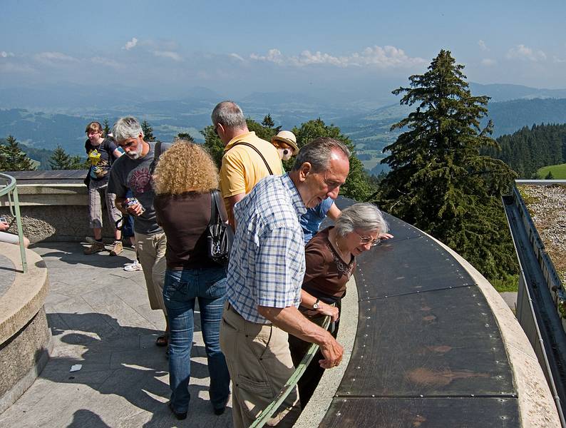 Karl showing Joyce some of the surrounding peaks on the copper plates.<br />The actual peaks cound not be seen due to a heavy haze.<br />August 1, 2011 - Atop the Pfnder above Bregenz, Austria.