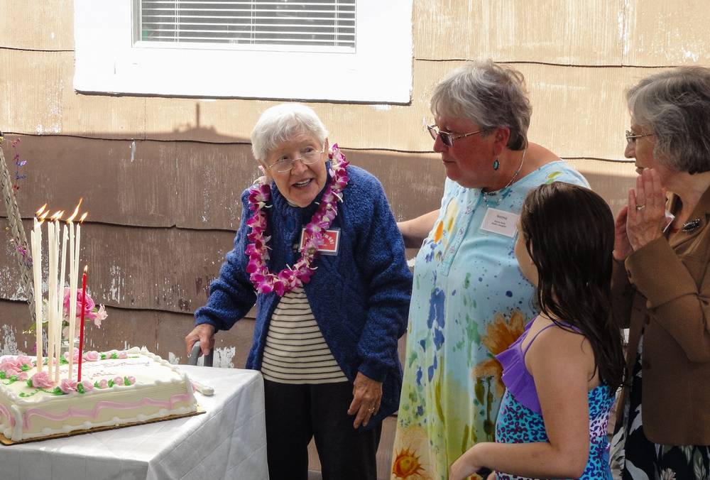 Marie about to blow out the candles with daughters Norma and Joyce and greatgranddaughter Miranda watching.