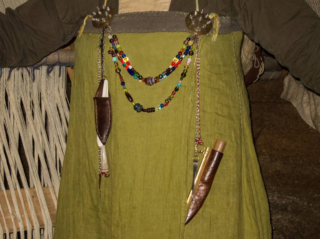 Jewelry and tools hanging in front of the apron.<br />July 9, 2012 - L'Anse aux Meadows National Historic Site, Newfoundland, Canada.