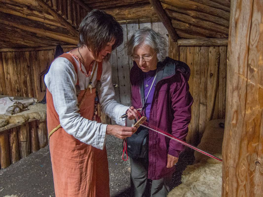 Gudrid (her character name) showing Joyce a method of weaving.<br />July 9, 2012 - Norstead Viking Village, L'Anse aux Meadows, Newfoundland, Canada.