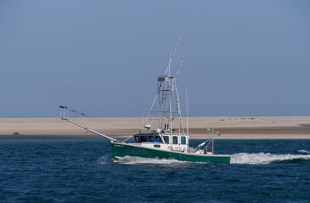 Fishing boat off Chatham Lighthouse Beach.<br />June 20, 2013 - Chatham, Massachusetts.