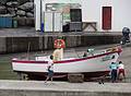 A boat being dragged away from the water and an Yves artwork in back.<br />July 12, 2013 - Lagoa, Sao Miguel, Azores, Portugal.