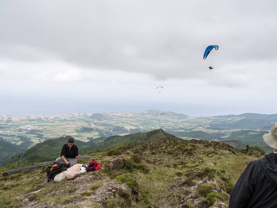 A third paraglider goes by while Melody is unpacking her wings.<br />July 12, 2013 - Pico do Fogo, Sao Miguel, Azores, Portugal.