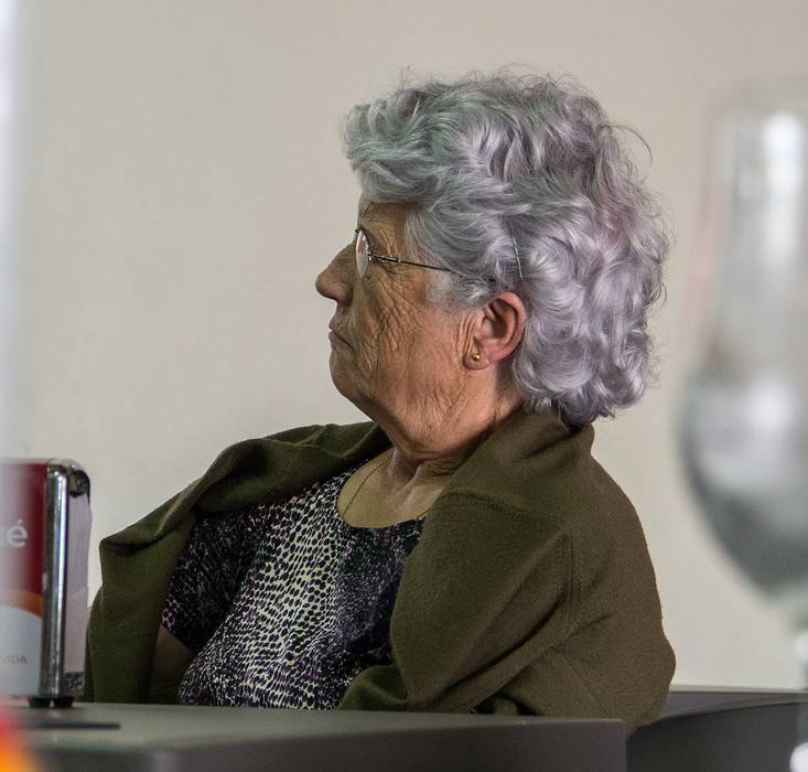 Local woman watching parade in Ponta Delgada on TV.<br />Bar Casa do Povo.<br />July 13, 2013 - Sete Cidades, Sao Miguel, Azores, Portugal.