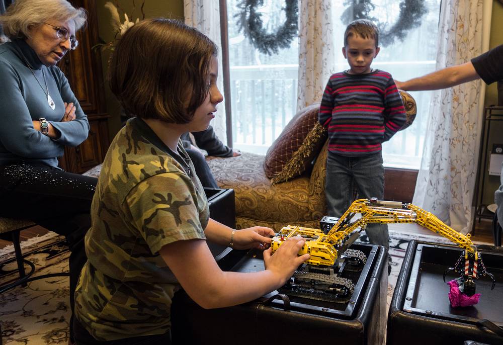 Miranda playing with a Lego crane that she put together. Joyce and Matthew watching.<br />Dec. 26, 2013 - At Carl and Holly's in Mendon, Massachusetts.