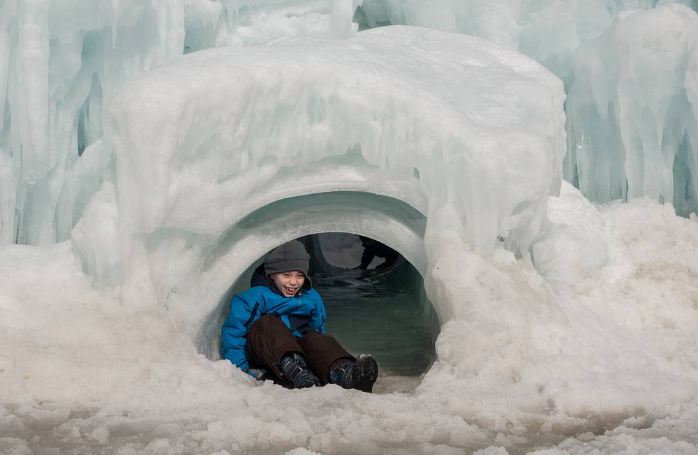 Matthew emerging from the tunnel slide.<br />Ice Castle at Loon Mountain.<br />Feb. 22, 2014 - Lincoln, New Hampshire.