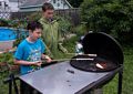 Marks and Zachary baking dough on a stick.<br />July 19, 2014 - At Marie's in Lawrence, Massachusetts.