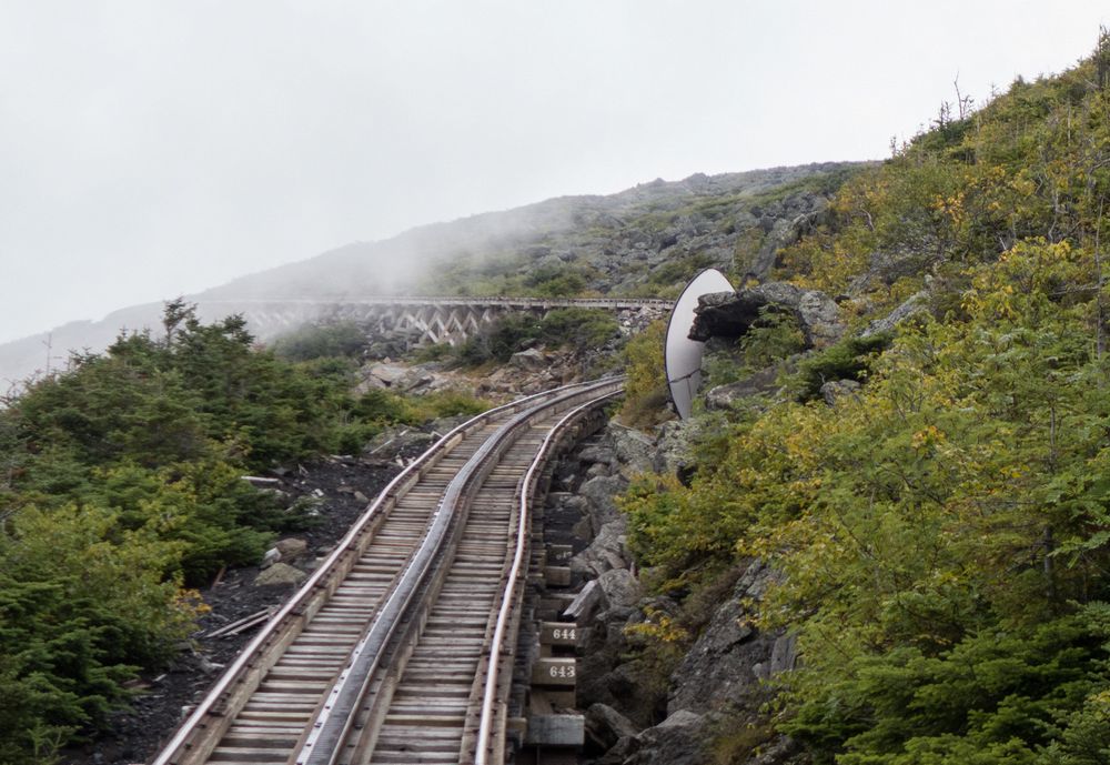 A face in the rock highlighted against a white backdrop.<br />Aug. 22, 2014 - Cog Railway, Mount Washington, New Hampshire