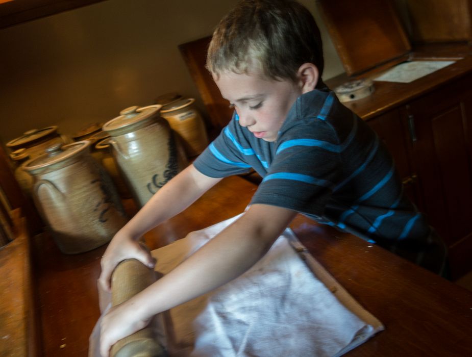 Matthew crushing crackers in the pantry of the 1890 Farm House.<br />July 14, 2015 - Biliings Farm and Museum in Woodstock, Vermont.