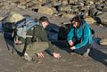 Sati photographing shells while Melody watches.<br />Dec. 25. 2015 - Parker River National Wildlife Refuge, Plum Island, Massachusetts.