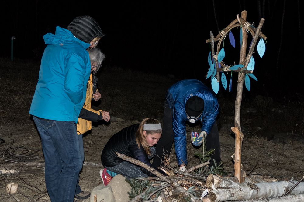 Carol and Joyce watch as Sonya and Micheal are trying to light the bonfire.<br />March 19, 2016 - At Michael and Kathleen's in Campton, New Hampshire.