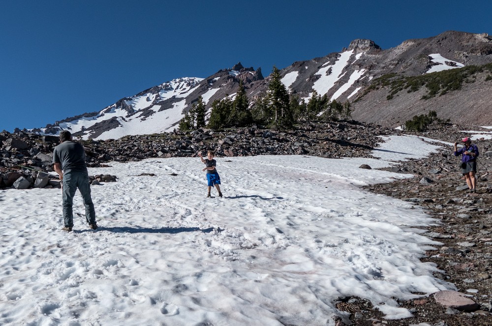 Sati and Matthew in a snowball fight while Melody photographs them.<br />Short hike above Panther Meadow parking area.<br />July 20, 2016 - Mount Shasta, California.