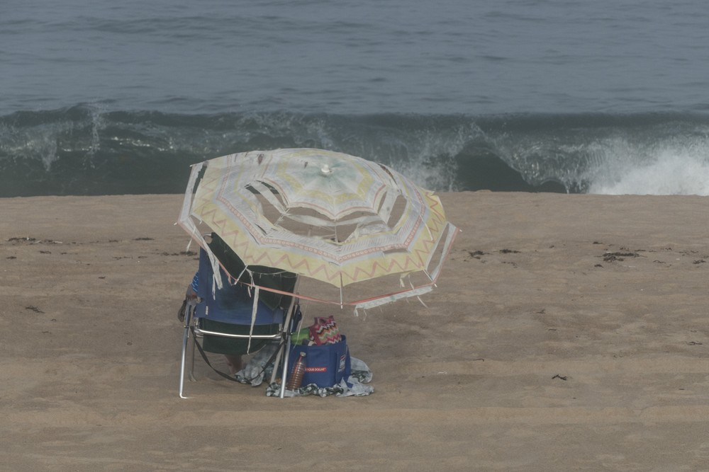 Woman under tattered umbrella.<br />Sept. 8, 2016 - Parker River National Wildlife Refuge, Plum Island, Massachusetts.