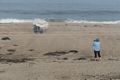 Joyce photographing woman under tattered umbrella.<br />Sept. 8, 2016 - Parker River National Wildlife Refuge, Plum Island, Massachusetts.