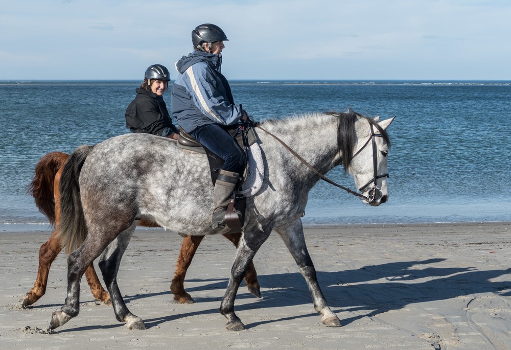 Two women on horseback.<br />Feb. 24, 2017 - Crane Beach, Ipswich, Massachusetts.