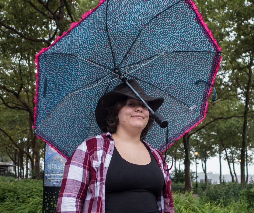 Miranda doing a balancing act with her unbrella.<br />Battery Park.<br />July 13, 2017 - Manhattan, New York City, New  York.