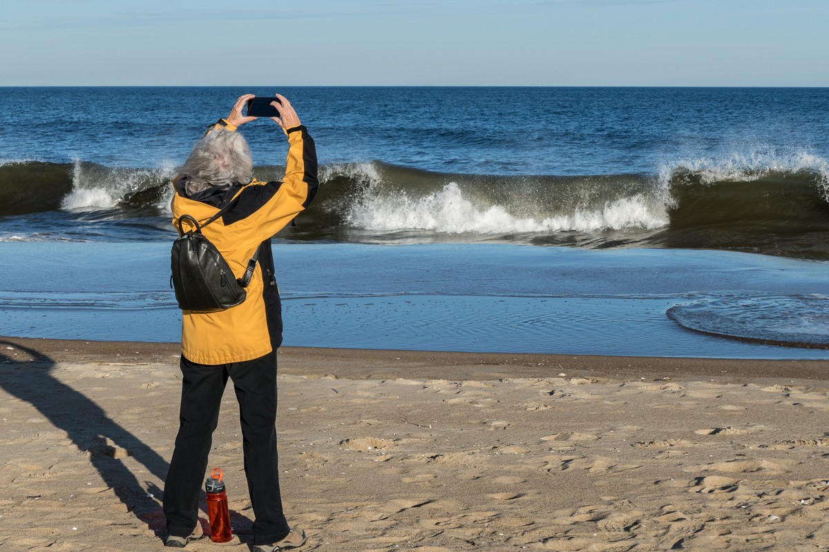 Joyce photographing a wave.<br />A walk with Joyce, Carl, and Matthew.<br />Nov. 25, 2017 - Parker River National Wildlife Refuge, Plum Island, Massachusetts.