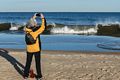 Joyce photographing a wave.<br />A walk with Joyce, Carl, and Matthew.<br />Nov. 25, 2017 - Parker River National Wildlife Refuge, Plum Island, Massachusetts.
