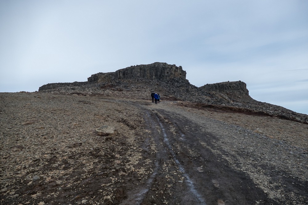 Eric, Joyce, and Marks heading for the volcanic plug of columnar basalt.<br />April 17, 2017 - At Borgarvirki off Rte. 1, Iceland.