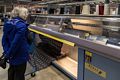 Joyce watching a knitting machine spit out hundreds of puffins.<br />Kidka Wool Factory Shop.<br />April 18, 2017 - Hvammstangi, Iceland.