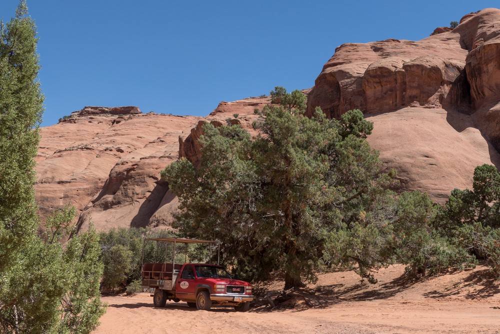 Our tour truck in the shade of an evergreen.<br />On tour with Navajo Spirit Tours.<br />Aug. 14, 2017 - Monument Valley Navajo Tribal Park, Arizona.