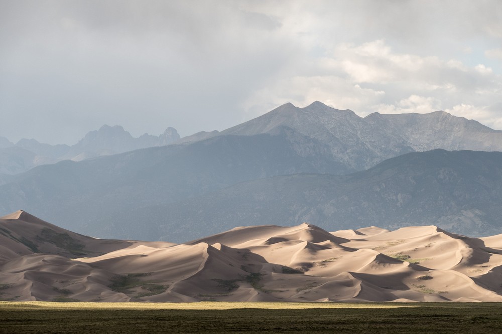 View of dunes of the Great Sand Dunes National Park with Sangre de Cristo mountains in back.<br />Aug. 17, 2017 - Great Sand Dunes Lodge, Mosca, Colorado.