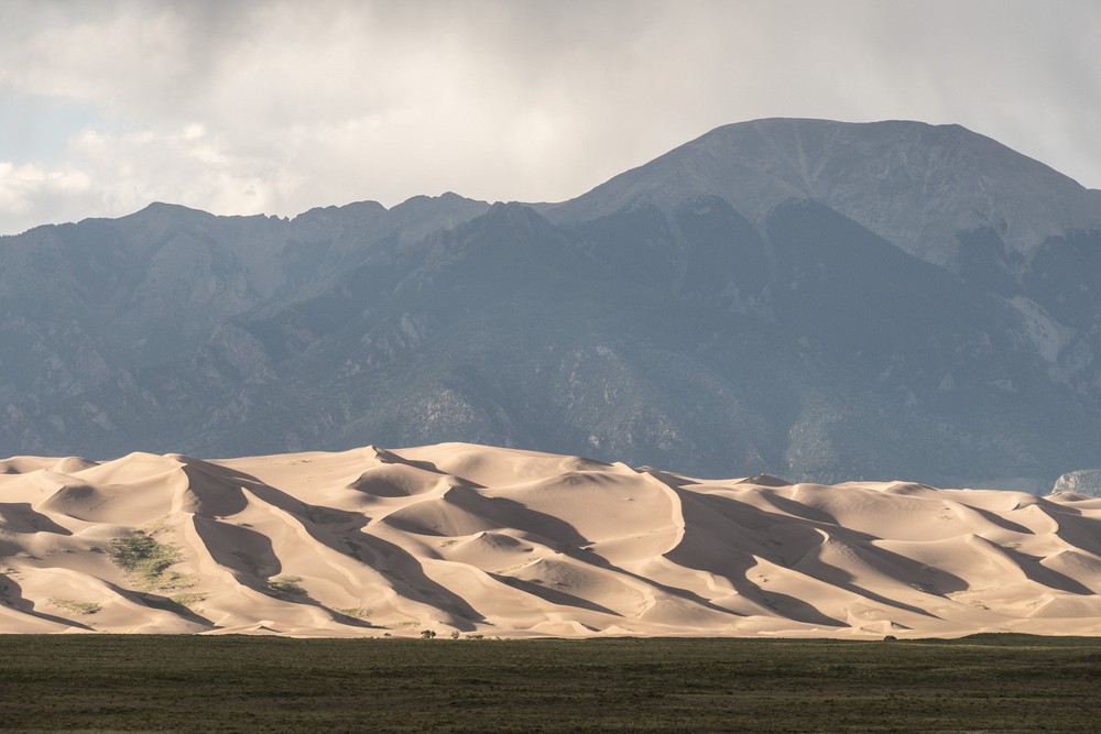 View of dunes of the Great Sand Dunes National Park with Sangre de Cristo mountains in back.<br />Aug. 17, 2017 - Great Sand Dunes Lodge, Mosca, Colorado.