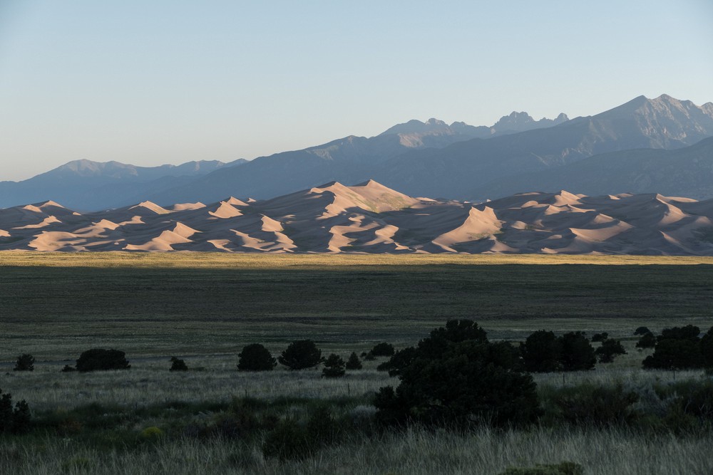 View of dunes of the Great Sand Dunes National Park at sunrise with the Sangre de Cristo Mountains in back.<br />Aug. 18, 2017 - Great Sand Dunes Lodge, Mosca, Colorado.