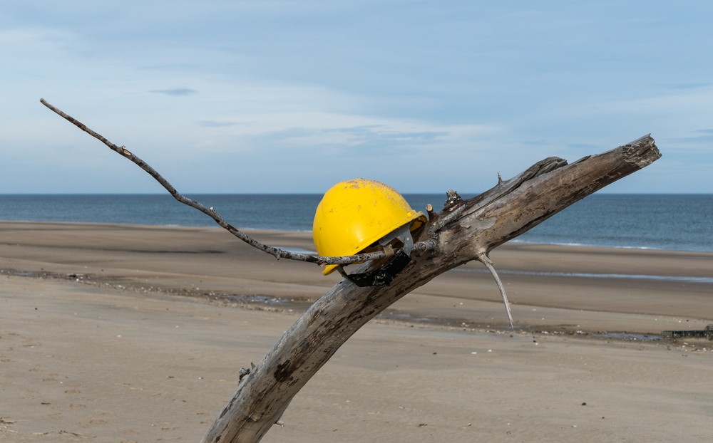 A bright yellow hard hat placed on driftwood.<br />A second day at Plum Island on a balmy (50 degree) day.<br />Jan. 11, 2018 - Parker River National Wildlife <br />Refuge, Plum Island, Massachusetts.