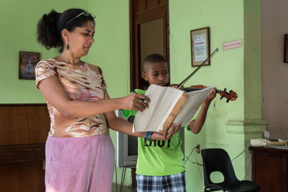 Director Wilma Ynez holding the score for 11 year old Abdoo, a Yemeni student.<br />"Lauro Fuentes" Community Music School <br />Nov. 1, 2016 - Santiago de Cuba.